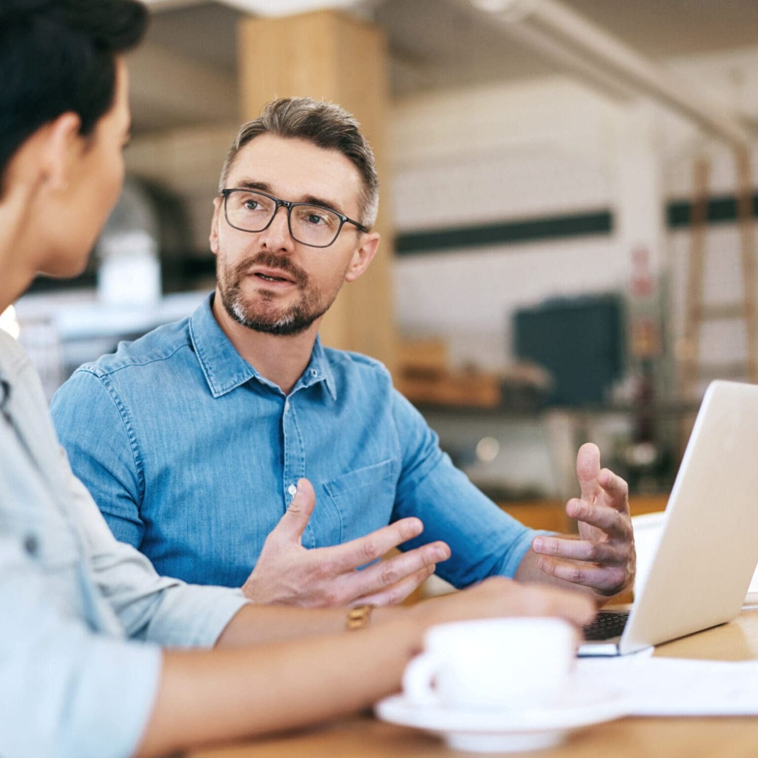 Sales executive consulting with client at desk